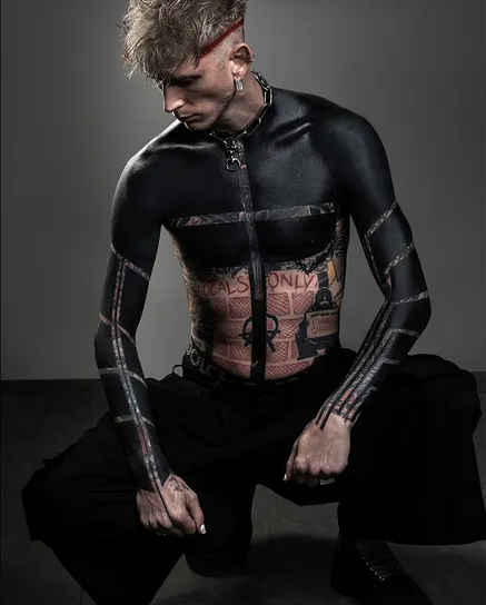 Machine Gun Kelly debuts dramatic upper torso blackout tattoo